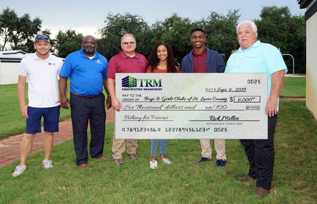 A group of people posing for a picture with a check.