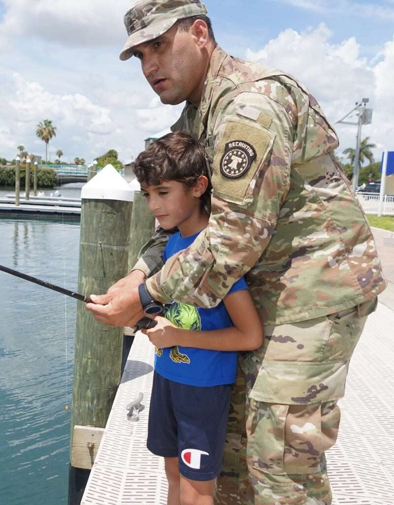 An Officer Helping A Kid With Fishing